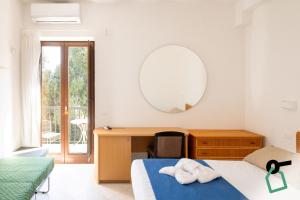 a bedroom with a bed and a desk and a mirror at Hotiday Fasano Mare in Savelletri di Fasano