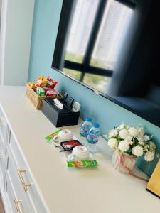 a white counter with flowers and drinks and a mirror at Ocean Homes cơ sở SH24 in Ðình Loan