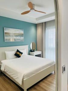 a bedroom with a white bed with a ceiling fan at Ocean Homes cơ sở SH24 in Ðình Loan +26 photos