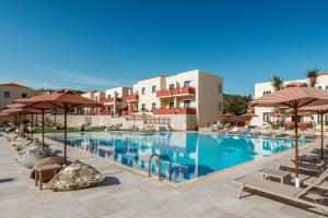a large swimming pool with chairs and umbrellas at Kambos Village in Agia Marina Nea Kydonias