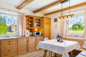 a kitchen with a table and some windows at Die Gemütliche Fewo in Breitenberg