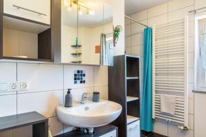 a bathroom with a sink and a mirror at Die Gemütliche Fewo in Breitenberg +23 photos