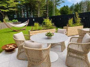 a patio with a table and chairs and a hammock at Villa Vendel B&B in Løkken
