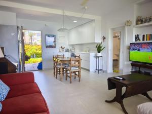 a living room with a couch and a table with a tv at Calma Bungalow 54b en Urbanización La Roca in Torremolinos