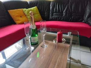 a bottle of champagne and two glasses on a table at Ferienhaus Tindy am Silbersee in Frielendorf