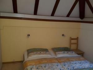 a bed with two pillows on it in a bedroom at Ferienhaus Tindy am Silbersee in Frielendorf