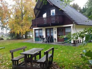 a picnic table in front of a house at Ferienhaus Tindy am Silbersee in Frielendorf