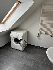 a laundry room with a washer and a sink at Hochwertige Monteurunterkunft in Zarrentin