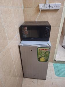 eine Mikrowelle, die auf einem Kühlschrank steht in der Unterkunft Ur place in al-Ain