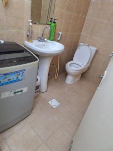 ein Badezimmer mit Waschbecken, Toilette und Waschbecken in der Unterkunft Ur place in al-Ain