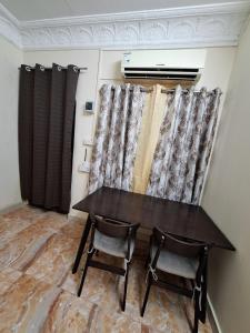 ein Tisch und zwei Stühle in einem Raum mit Vorhängen in der Unterkunft Ur place in al-Ain