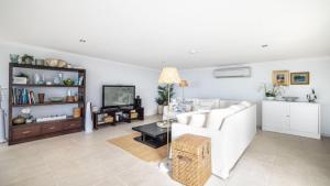 a living room with a white couch and a tv at The Lookout in Woorim