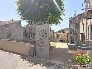 a gate to a house with a fence at Le Chardonneret du Sancy in Montaigut-le-Blanc