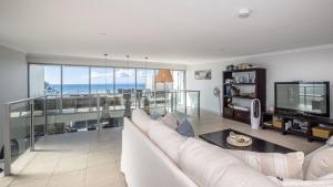 a living room with a white couch and a television at The Lookout in Woorim