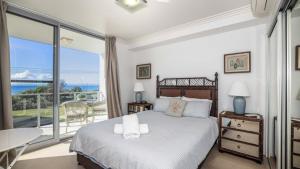 a bedroom with a bed with a view of the ocean at The Lookout in Woorim +16 photos