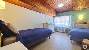 a bedroom with two beds and a wooden ceiling at Chez l'tiote morvandelle in Montigny-en-Morvan