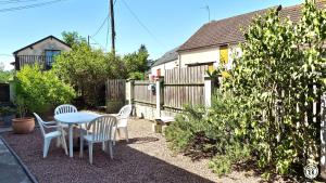 a patio with a table and chairs and a fence at Chez l'tiote morvandelle in Montigny-en-Morvan
