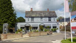 a large white building on the corner of a street at Nestledstays - The Hide in Walberton