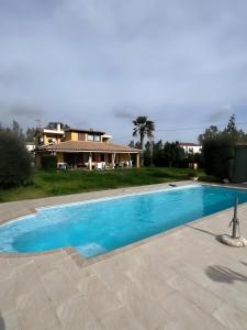 ein Swimmingpool vor einem Haus in der Unterkunft Masone Verde in Castiadas