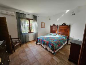 ein Schlafzimmer mit einem Bett mit hölzernem Kopfteil in der Unterkunft Masone Verde in Castiadas