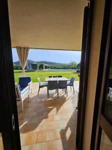 Blick auf eine Terrasse mit Tisch und Stühlen in der Unterkunft Masone Verde in Castiadas