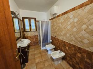 ein Badezimmer mit zwei Waschbecken und einer Toilette in der Unterkunft Masone Verde in Castiadas + 27 Fotos