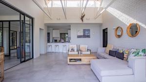 a living room with a couch and a table at Sunset Bay Stay in Hout Bay