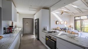 a kitchen with white cabinets and a counter top at Sunset Bay Stay in Hout Bay +52 photos