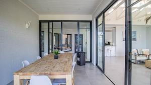 a dining room with a wooden table and chairs at Sunset Bay Stay in Hout Bay