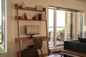 a room with a desk with a computer and a window at 102 - Upscale Condo - River View Terrace in Baie-Saint-Paul +44 photos