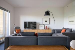 a living room with a couch and a tv at 102 - Upscale Condo - River View Terrace in Baie-Saint-Paul