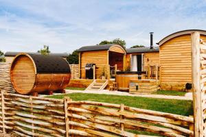 a house with a wooden fence in the yard at Nestledstays – The Meadow in Binsted