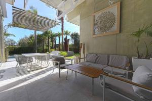 a patio with a couch and a table and chairs at Villa Nola - Diseño Vasco, Lujo y Privacidad in San Sebastián