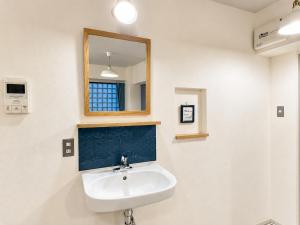 a bathroom with a sink and a mirror at Eight One in Osaka