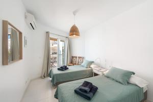 a room with two beds with towels on them at Apartment Overlooking the Beach in Marbella +25 photos