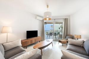 a living room with a couch and a tv at Apartment Overlooking the Beach in Marbella
