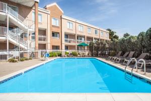 a swimming pool in front of a apartment building at Baymont by Wyndham Madison Heights Detroit Area in Madison Heights