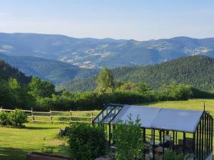 a greenhouse in a field with mountains in the background at Braeschenberg in Breitenbach-Haut-Rhin