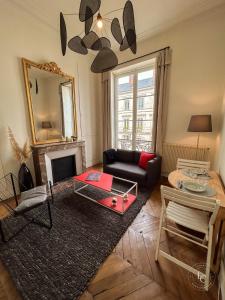 a living room with a couch and a table at La Cathédrale - 47 m2 - 1 bedroom in Orléans +23 photos