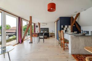 a kitchen and living room with a table and chairs at La Grange in Reichstett