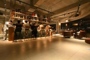 a group of people sitting at a bar in a restaurant at F18 Hub Youth Hostel in Chengdu