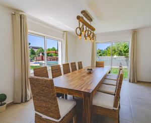 a dining room with a wooden table and chairs at Villa Ursa by Algarve Holidays in Praia do Carvoeiro