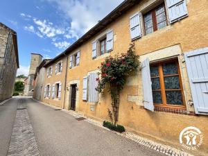 an empty street with a building with flowers on it at La Chambre des Tours in Biran
