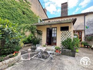 a patio with a table and chairs in front of a building at La Chambre des Tours in Biran +8 photos
