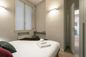 a bedroom with a white bed with towels on it at GuestHost - Vivaldi Autunno Apartment in Treviglio