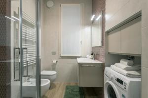 a bathroom with a toilet sink and a washing machine at GuestHost - Vivaldi Autunno Apartment in Treviglio +16 photos
