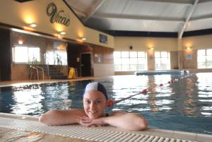 un hombre yace en una piscina en Maldron Hotel Wexford en Wexford