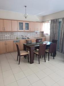 a kitchen with a dining room table and chairs at Gialova Relax in Korifásion
