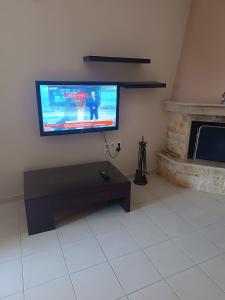 a living room with a flat screen tv on the wall at Gialova Relax in Korifásion