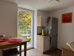 a small kitchen with a table and a refrigerator at NEU! Kleines Glück Illingen in Illingen